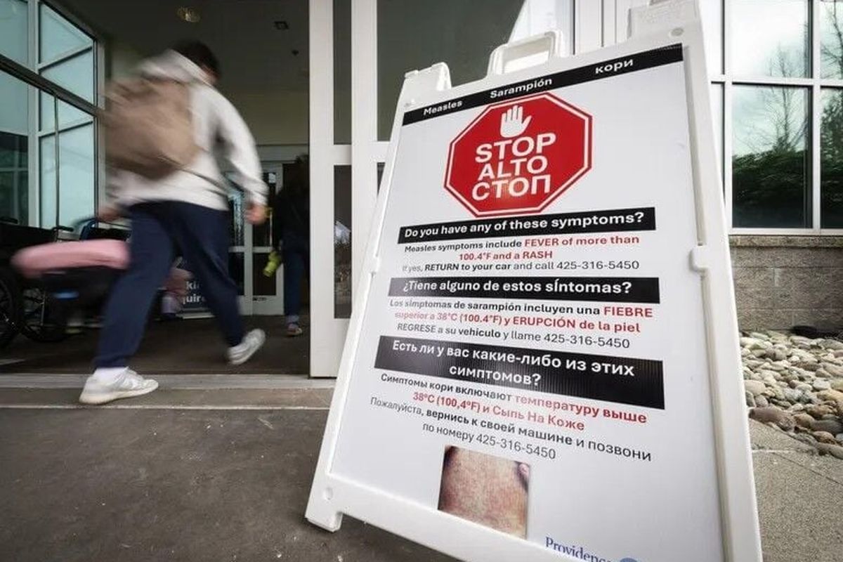 A sign warns people with symptoms of measles not to enter a Providence walk-in clinic in Everett. Over the last few months, the hospital system has joined Snohomish County’s response to a measles outbreak, including testing patients, administering MMR vaccines and making sure staff are familiar with symptoms.  (Seattle Times)