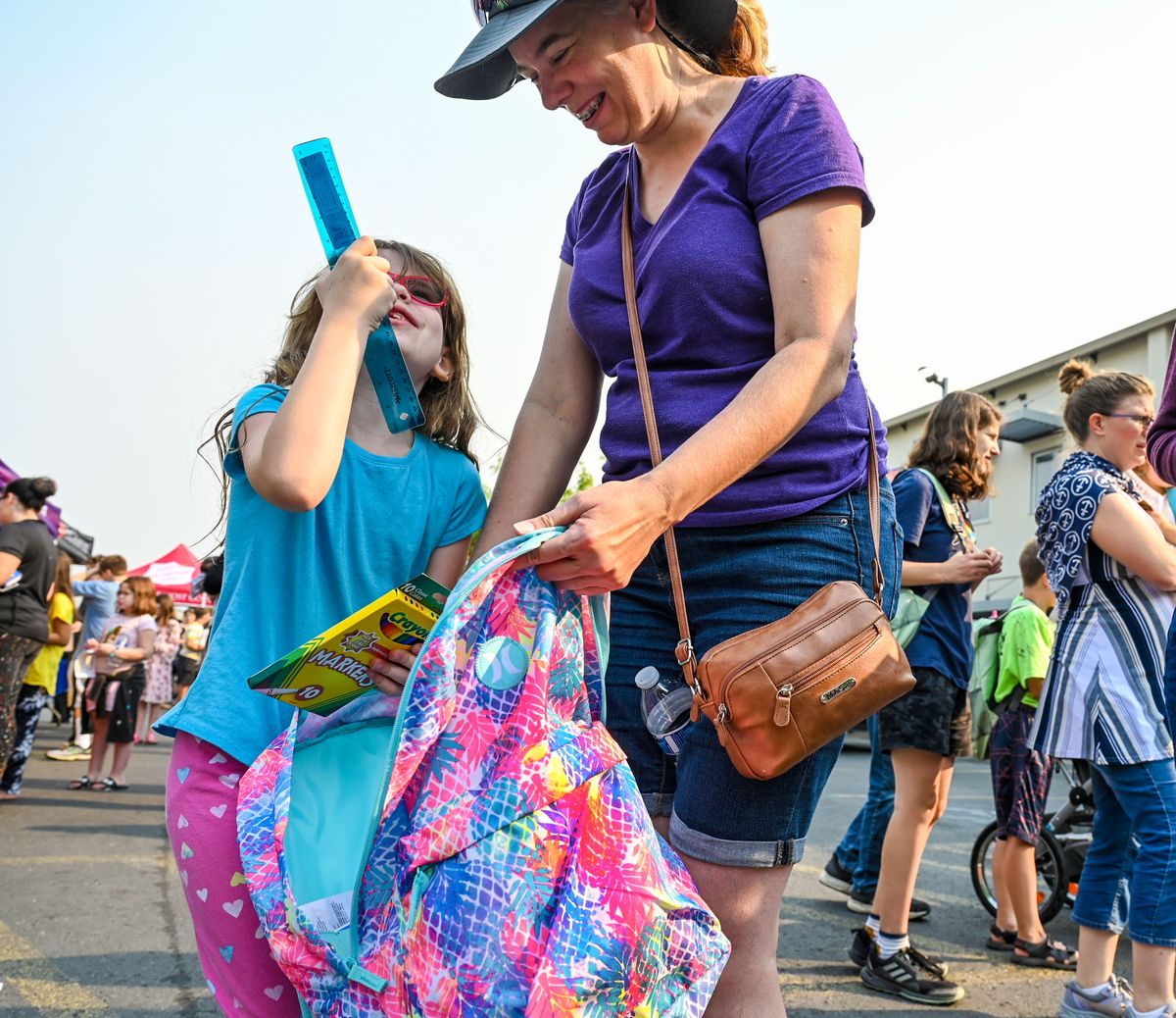 Victoria Weaver reveals the school supplies contents to her mother, Betsy, after finding a finding a backpack to match her outfit during the 14th Annual Backpack for Kids event at The Salvation Army on Wednesday in Spokane.  (DAN PELLE/THE SPOKESMAN-REVIEW)