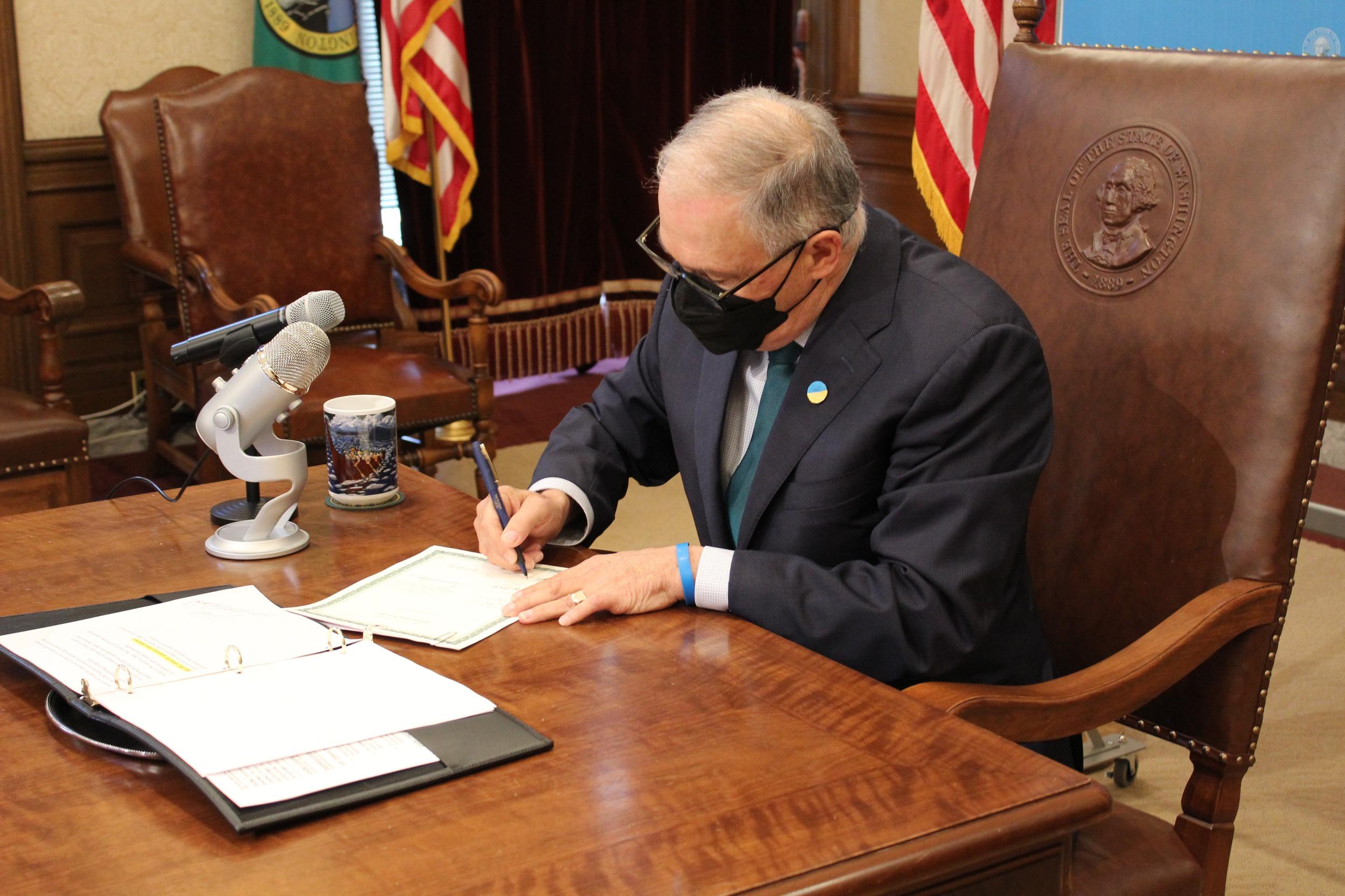 Gov. Jay Inslee signs a bill improving access to abortions in Washington into law Thursday at the Washington State Legislative Building in Olympia. Inslee also signed a bill changing the definition of use of force into law on Thursday.  (By Albert James / The Spokesman-Review)