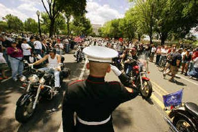 
U.S. Marine Staff Sgt. Tim Chambers, of Twentynine Palms, Calif., salutes bikers at the Rolling Thunder memorial ride in Washington, D.C., on Sunday. 
 (Associated Press / The Spokesman-Review)