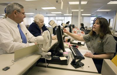 Department of Licensing employee Toni Kornec, right, helps Ron Davenroth  and his mother, Jean Davenroth, with  ID cards in Auburn, Wash., on  March 27, the last day of operation at the office.  (Associated Press / The Spokesman-Review)