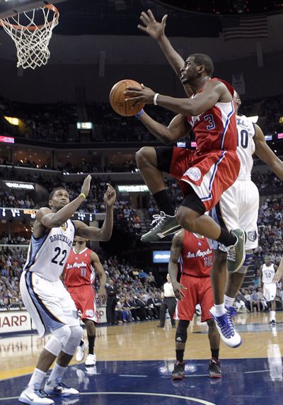 Clippers guard Chris Paul (3) goes to the basket against Grizzlies' Rudy Gay (22) and Gilbert Arenas, right. (Associated Press)