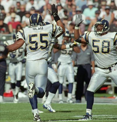 San Diego Chargers inside linebacker Junior Seau (55) is congratulated by outside linebacker Lew Bush (58) after making a tackle in a 1997 game at Oakland, Calif.  (Paul Sakuma / Associated Press)