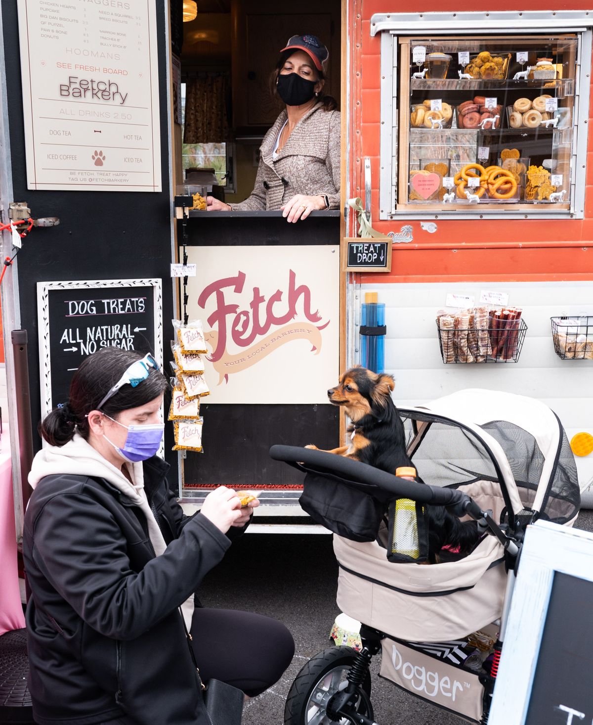 After buying a dog treat from Fetch Barkery owner Susan Smith, a vendor at the Spring Market at the Pavilion, Melanie Denton feeds it to her dog, Luna, on Wednesday in Riverfront Park.  (COLIN MULVANY/THE SPOKESMAN-REVI)