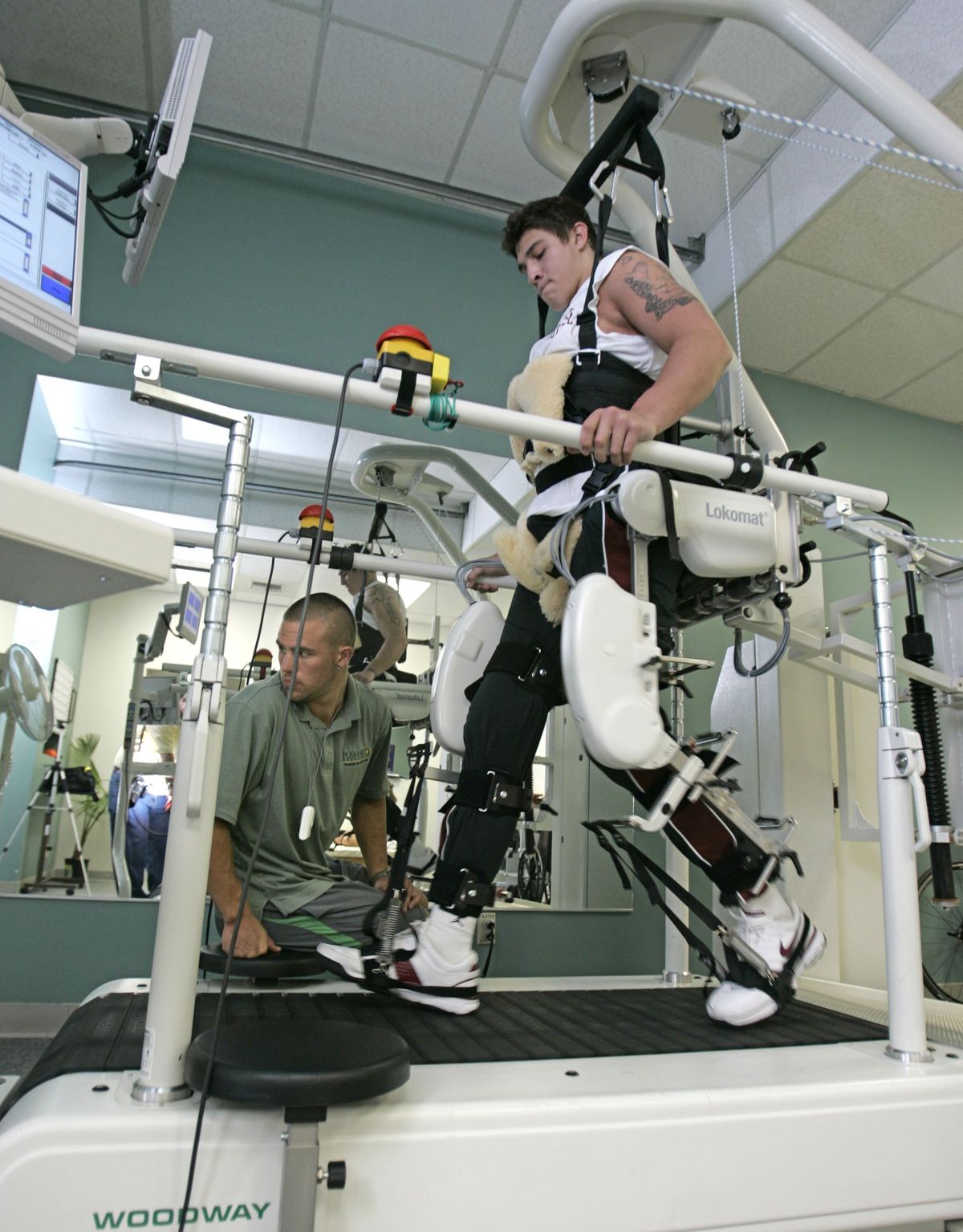 Cory Mackay uses the Lokomat, which walks his paralyzed legs as therapist Ben Lovelace monitors. Seattle Times (Jim Bates Seattle Times / The Spokesman-Review)