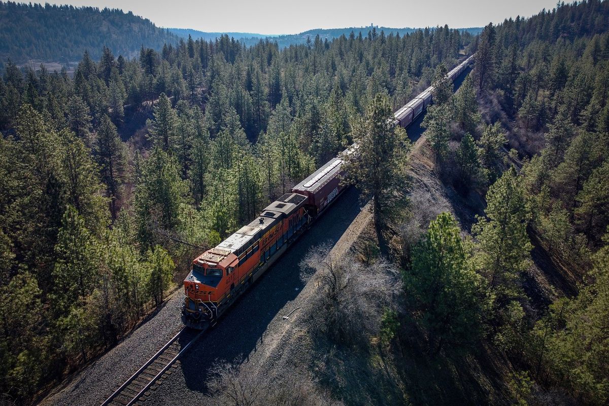 A BNSF locomotive, pushing from the tail end of a long train, travels over Thorpe Road and moves south out of Spokane on March 20. (Jesse Tinsley/The Spokesman-Review)