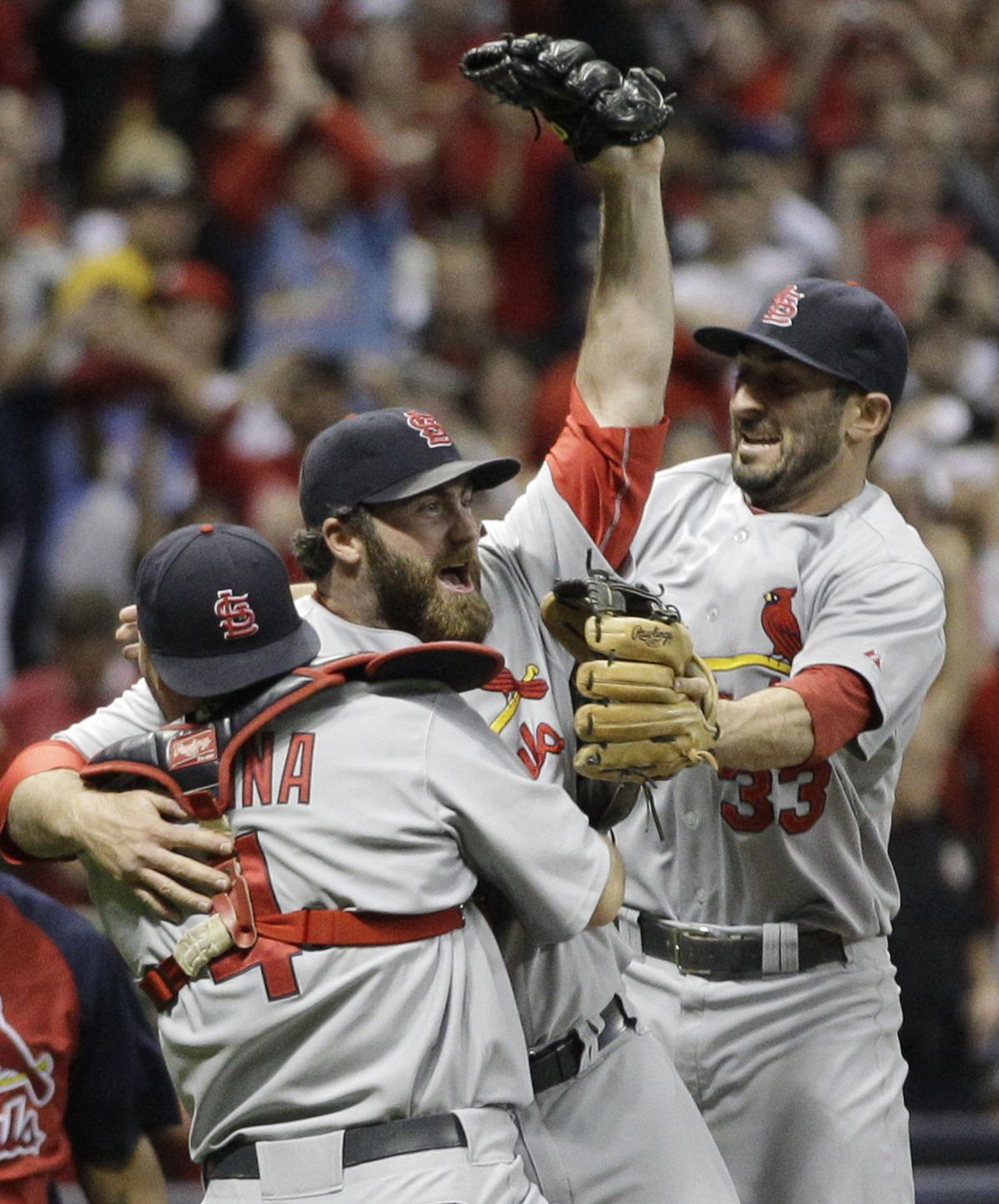 St. Louis’ Yadier Molina (4), Jason Motte and Daniel Descalso (33) celebrate after winning the N.L. pennant. (Associated Press)