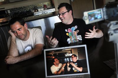 Remi Olsen, left, and Stefan Shipman record a weekly video podcast, “Remi and Stefan Do Spokane,” at Olsen’s condo in Spokane.  (Rajah Bose / The Spokesman-Review)