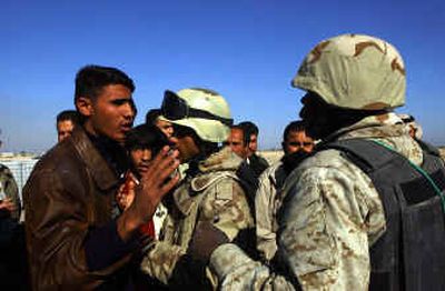 
A man argues with soldiers as he waits to enter Fallujah on Thursday. The first of the city's 300,000 residents who fled last month's offensive have started returning. 
 (Associated Press / The Spokesman-Review)