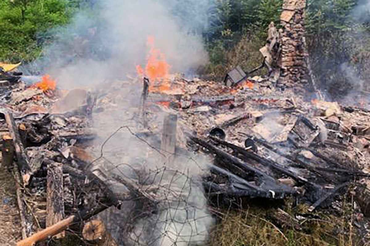In this photo provided by the Canterbury (New Hampshire) Fire Department, smoke rises Wednesday, Aug. 4, 2021, from the burnt remains of a cabin in Canterbury, N.H., inhabited by 81-year-old David Lidstone, who for 27 years has lived in the woods of New Hampshire along the Merrimack River in the once small, solar-paneled cabin. "River Dave," as he