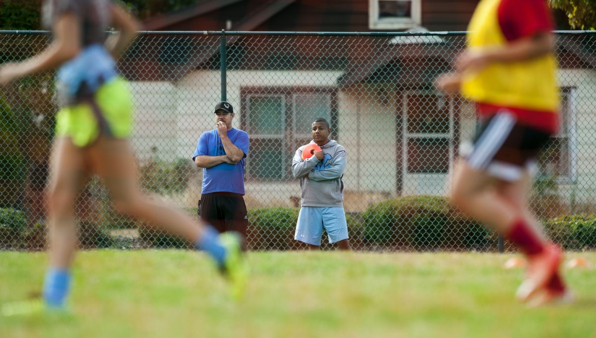 Central Valley soccer coach Andres Monrroy, right, watches team practice with assistant coach Ryan Dennison, left, on Wednesday at the Central Valley High School in Spokane Valley.