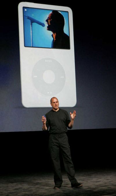 Apple Computer Inc. CEO Steve Jobs gestures as he shows the new iPod with U2 playing in the background during an unveiling in San Jose on Wednesday. 
 (Associated Press / The Spokesman-Review)