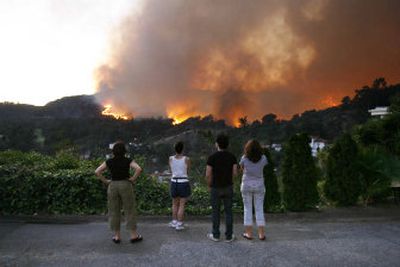 
Residents of the Los Feliz section of Los Angeles watch as a wildfire burns near their homes Tuesday. 
 (Associated Press / The Spokesman-Review)