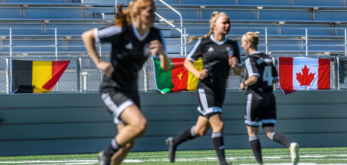 Team Germany warms up during practice flanked by flags from Belgium, Cameroon and Canada while the 92nd Air Refueling Wing Public Affairs hosts team media day, kicking off the 2022 13th Conseil International Du Sport Militaire (CISM) Women’s World Cup at Mead School District’s Union Stadium on Sunday, July 10, 2022  (Kathy Plonka/The Spokesman-Review)
