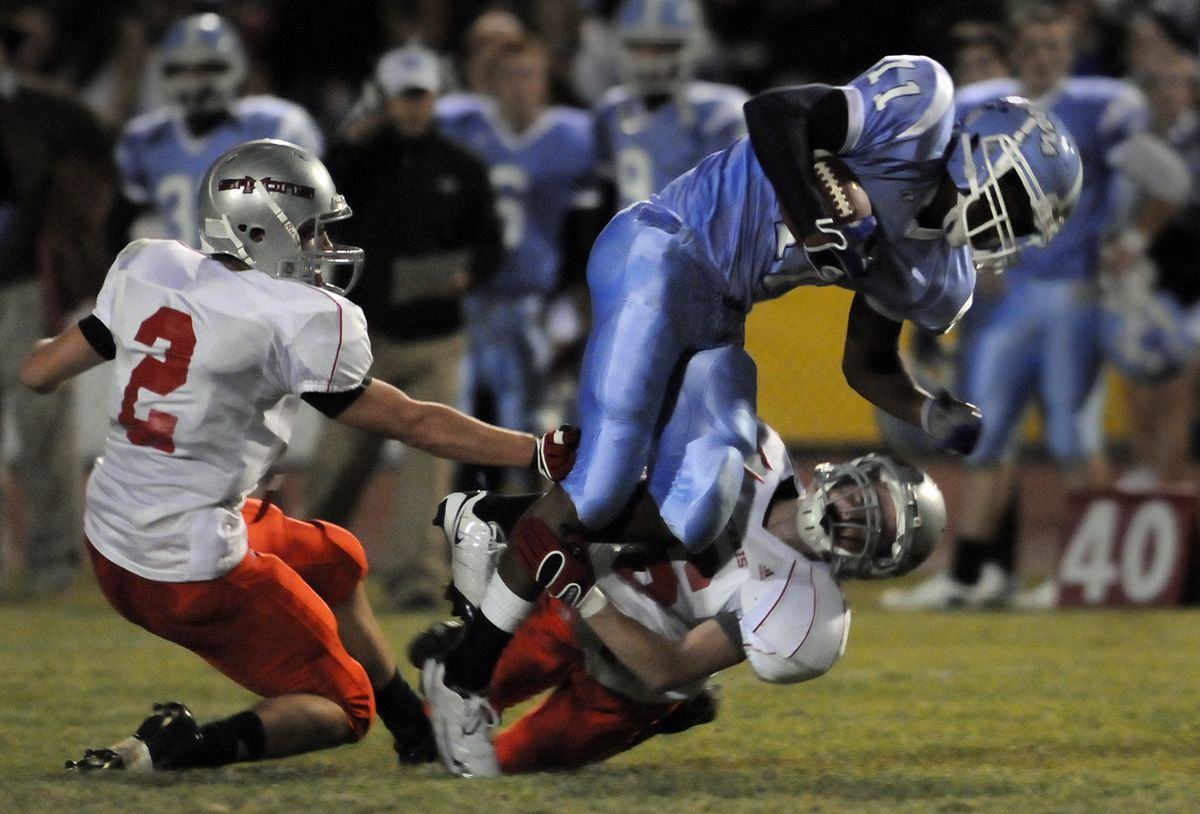 Central Valley running back Michael Williams is tripped up by Ferris defenders Grant Livingston, left, and C.J. Haney.   (Jesse Tinsley / The Spokesman-Review)