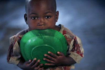 A displaced child chews on an empty plate  Saturday in Kibati  in eastern Congo. The U.N. refugee agency plans to move 60,000 Congolese caught between the front lines   this week.  (Associated Press / The Spokesman-Review)