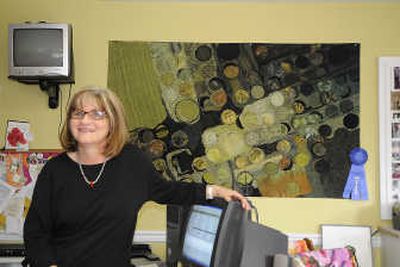 
Cheney fabric artist Pam Mostek sits for a portrait Wednesday  at her home in front of one of her pieces,  