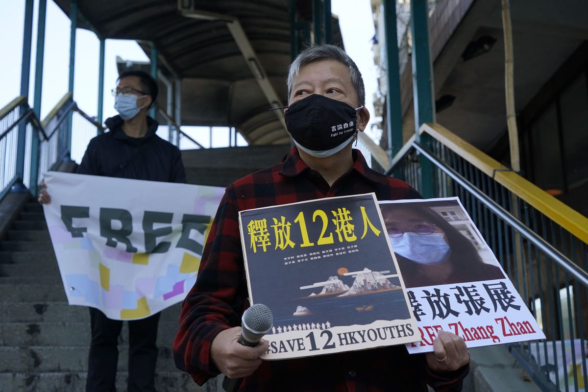 FILE - In this Dec. 28, 2020, file photo, pro-democracy activists, including Lee Cheuk-Yan, right, hold placards with the picture of journalist Zhang Zhan as they march to the Chinese central government