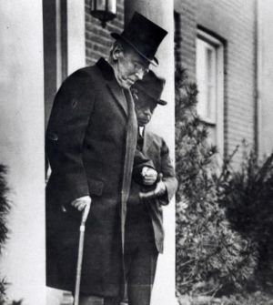 Former President Woodrow Wilson, with the help of an unidentified aide, leaves his Washington home in 1921. (Associated Press file photo)