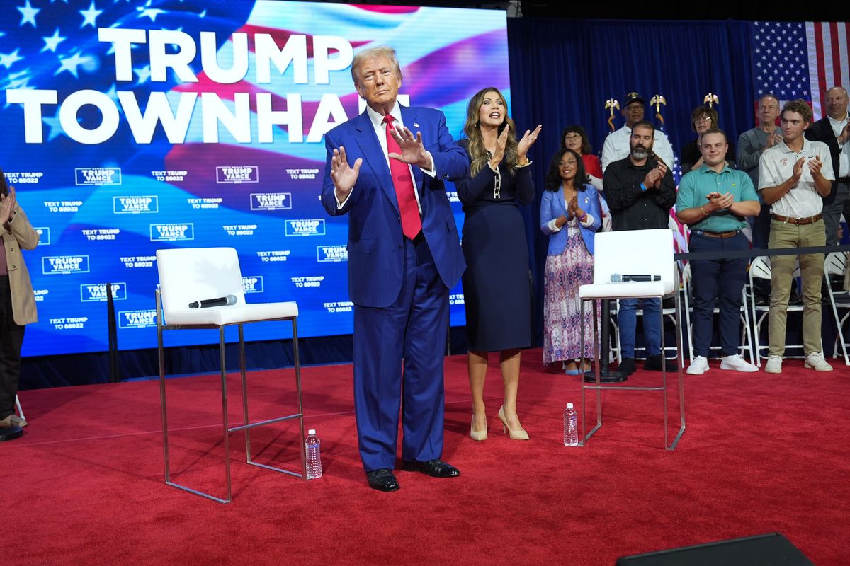 Former President Donald Trump, left, dances onstage with South Dakota Gov. Kristi Noem during a campaign town hall in Oaks, Pa., on Oct. 14.  (Jabin Botsford/The Washington Post)