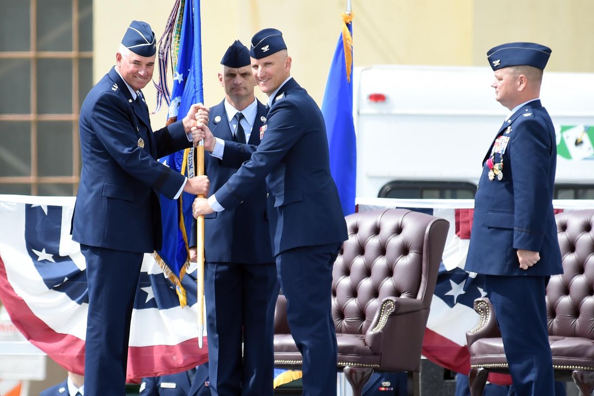 Lt. Gen.  Samuel Cox, left, and incoming commander of the 92nd Air Refueling Wing Col. Ryan Samuelson, third from left, pause for a picture during the ceremonial passing of the guidon, the unit flag, during the change of command Tuesday at Fairchild Air Force Base. Standing at right is outgoing commander Col. Charles B. McDaniel. Standing between the general and Col. Samuelson is Chief Master Sgt.  Chris Pugh. (Jesse Tinsley / The Spokesman-Review)