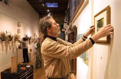 Art Spirit Gallery owner Steve Gibbs hangs some small oil paintings by artist Don Ealy in preparation for the opening of the small works show, which features 30 regional artists.
(Jesse Tinsley / The Spokesman-Review)