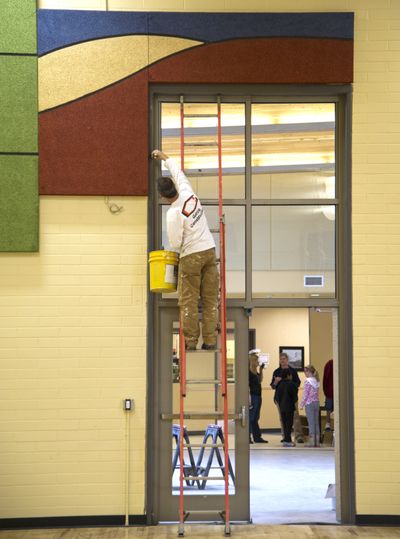 Marc Mattingly of Wayne Powell Painting paints window trim in the renovated Freeman Elementary School gym Monday. The Freeman School District is wrapping up construction of its new elementary school gym. There have been several phases of construction from a bond approved by voters in 2008. This is one of the last of them. (Colin Mulvany)