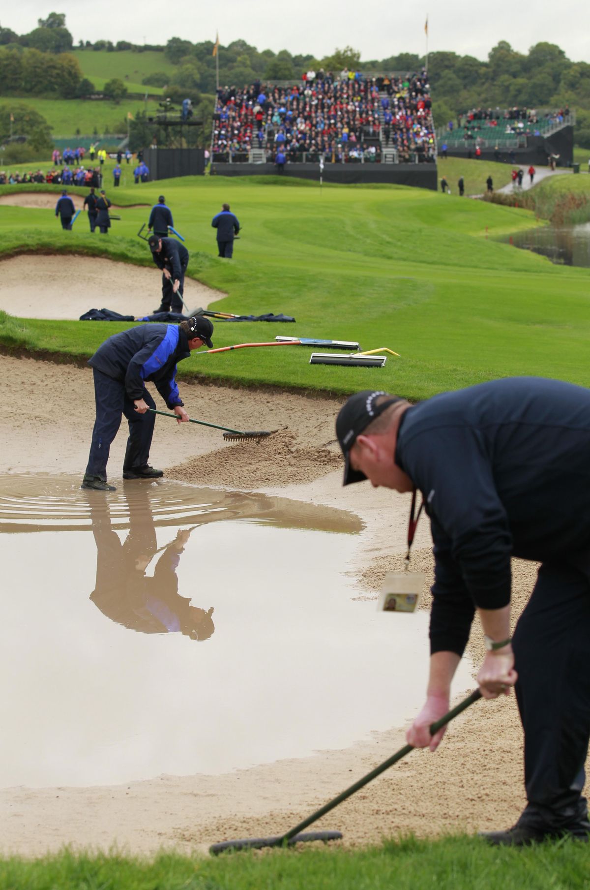 Greenkeepers prepare the bunkers after heavy rainfall suspended play during the 2010 Ryder Cup golf tournament at the Celtic Manor golf course in Newport, Wales, Friday, Oct.  1, 2010.  (Matt Dunham / Associated Press)