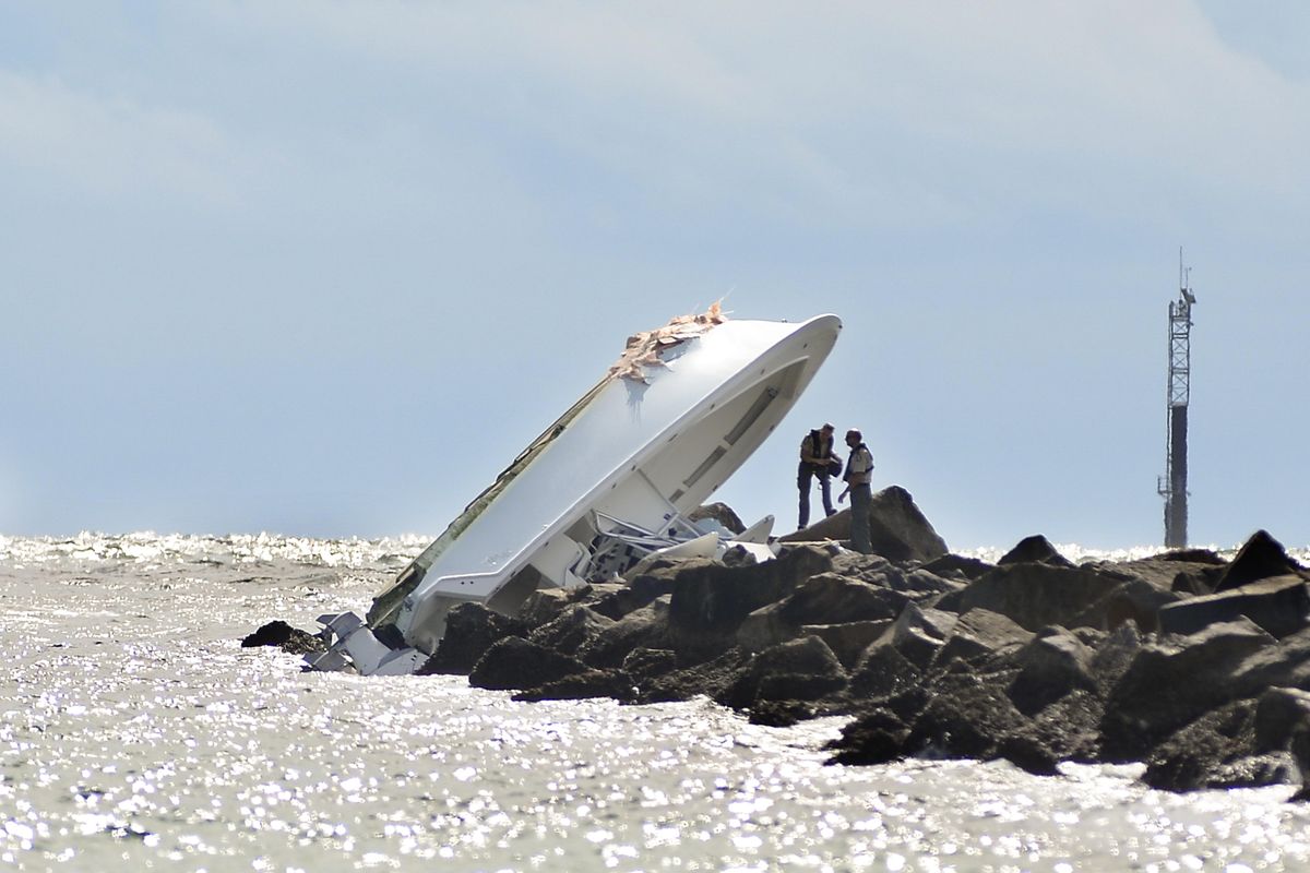 In this Sept. 25, 2016, file photo, investigators inspect an overturned boat as it rests on a jetty after a crash off Miami Beach, Fla. Miami Marlins pitcher Jose Fernandez was the “probable” operator of a speeding boat that crashed into a Miami Beach jetty on Sept. 25, 2016, killing the star baseball star and two other men, according to a report issued Thursday, March 16, 2017, by the Florida Fish and Wildlife Conservation Commission, which investigated the accident. (Gaston De Cardenas / Associated Press)