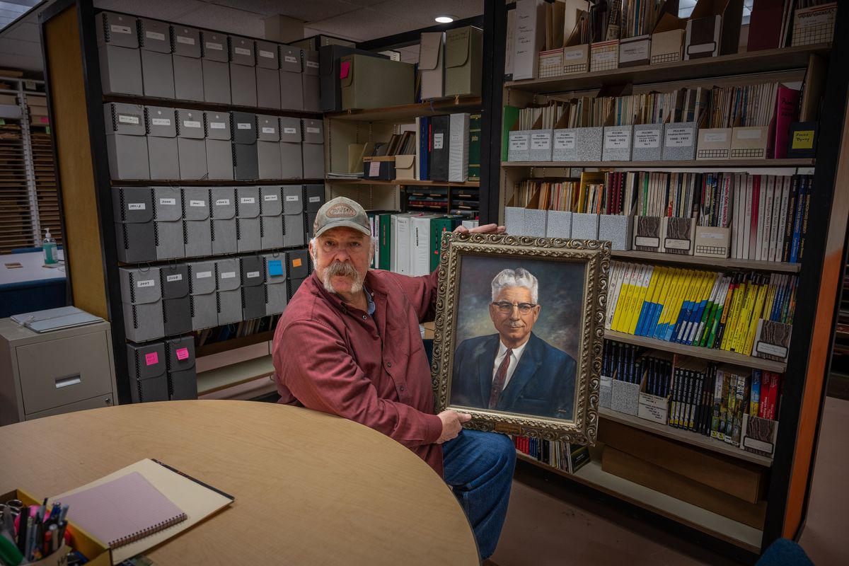 Alex Otero, archivist at the Whitman County Historical Society, holds a photo of Oscar Gladish, principal at Pullman High School from 1929-63 and the namesake of the Gladish Community Center.  (Jason Refsland/Murrow News Service)