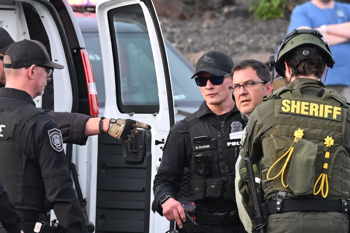 Former Spokane City Council President Ben Stuckart, second from right, is handcuffed and arrested by Spokane Police and Spokane Sheriff personnel Wednesday, June 11, 2025, during protests he had called for to interfere with the deportation of two men who had come to the U.S. legally and were seeking asylum and had been arrested by Immigration and Customs Enforcement personnel. (Jesse Tinsley/THE SPOKESMAN-REVIEW)