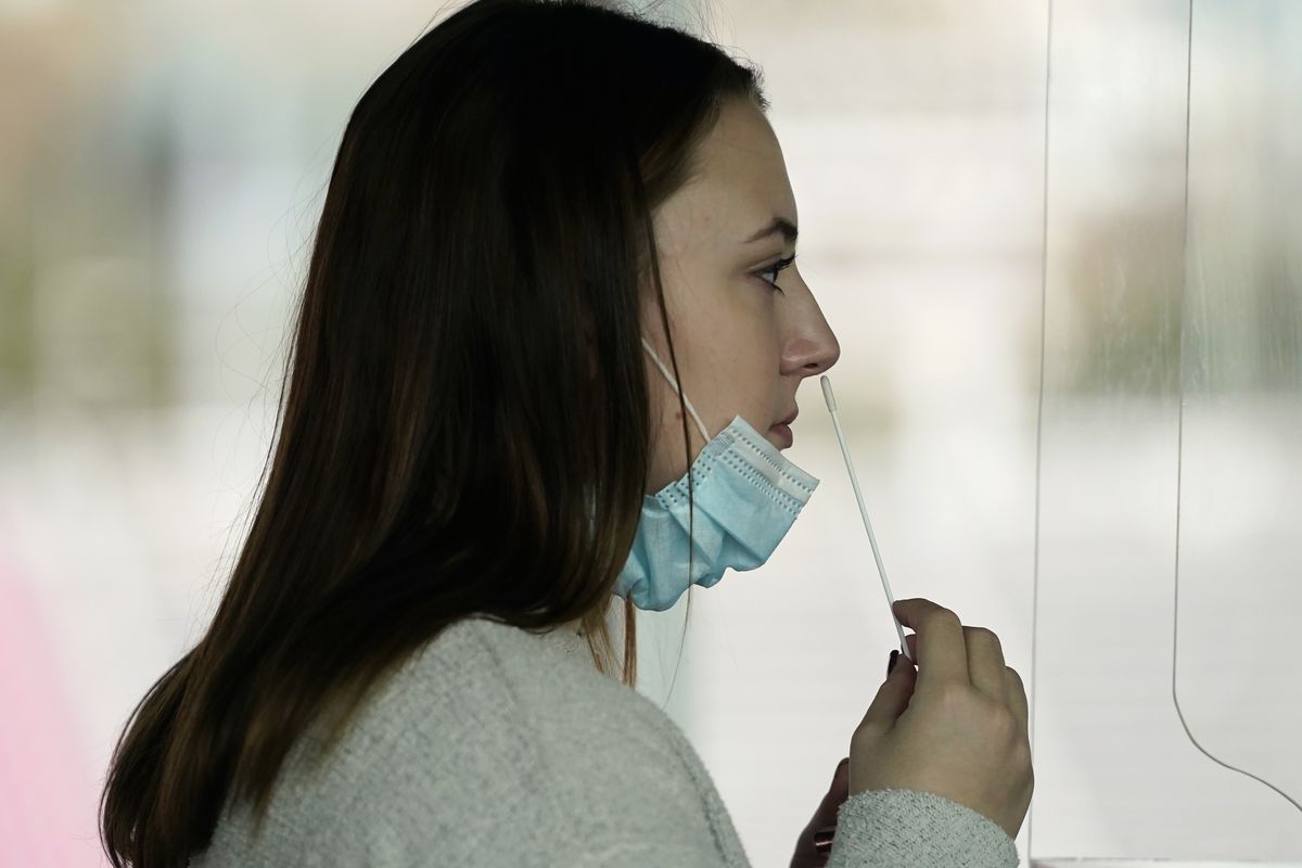 University of Utah student Abigail Shull takes a rapid COVID-19 test at the University of Utah student testing site Wednesday, Nov. 18, 2020, in Salt Lake City. As college students prepare to go home for the holidays, some schools are quickly ramping up COVID-19 testing to try to keep infections from spreading further as the coronavirus surges across the U.S.  (Rick Bowmer)