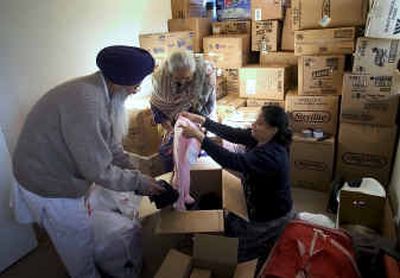 
At the Sikh Temple in Spokane Valley, Gurjeet Singh Aujla (Babaji), his wife, Jaswant Kaur Aujla, and VJ Pavani pack over 100 boxes of donated clothes for the survivors of the tsunami. The temple has also collected more than $20,000 in donations. Babaji said that people who have never been to the temple have been dropping off donations. 
 (Colin Mulvany / The Spokesman-Review)