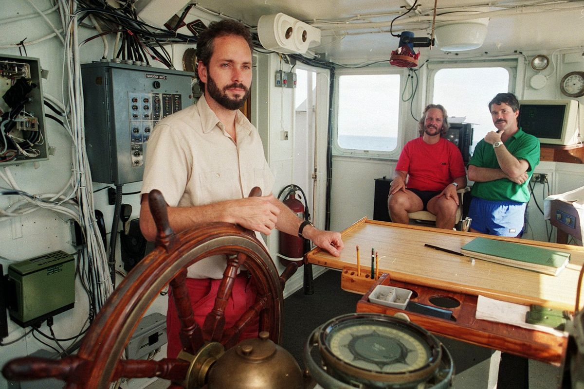 FILE - In this Aug. 29, 1991, file photo, Tommy Thompson stands at the helm of the Arctic Explorer as Bob Evans, center, and Barry Schatz look on in Norfolk, Va. Thompson, a former deep-sea treasure hunter, is about to mark his fifth year in jail for refusing to disclose the whereabouts of 500 missing gold coins found in the historic shipwreck of the S.S. Central America, known as the Ship of Gold.  (Doral Chenoweth III)