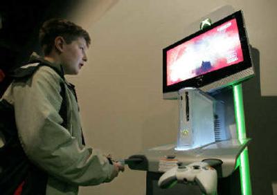 
With explosions happening on the screen, Will Amodei of Kent, Wash., tries out the Xbox 360 before the annual Microsoft shareholder meeting in Bellevue. 
 (Associated Press / The Spokesman-Review)