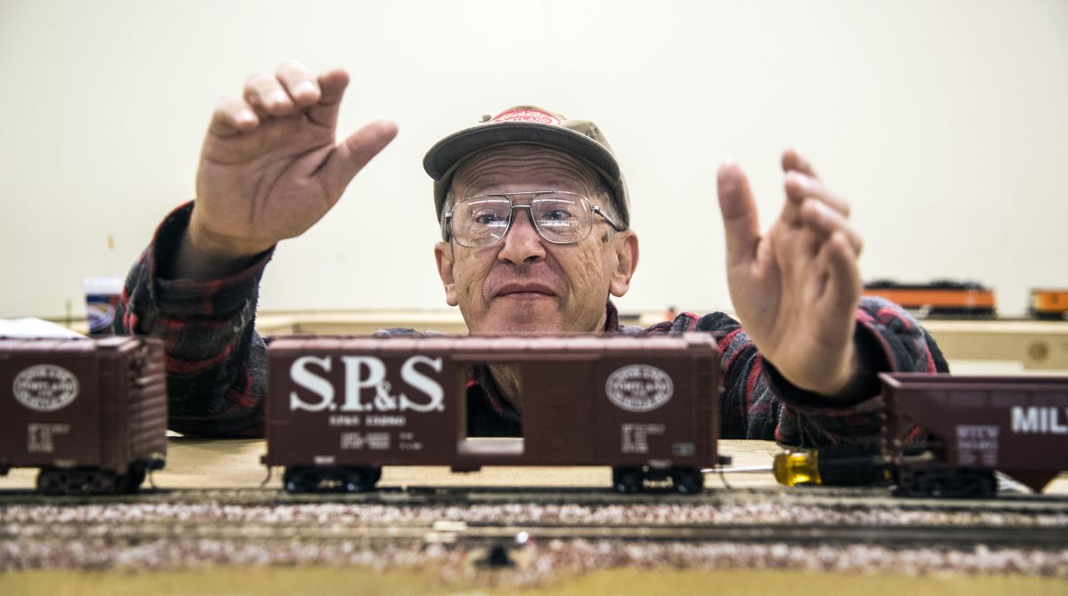 Max Kunze carefully places an O-scale model train car representing the SP&S (Spokane Portland & Seattle Railway) on the tracks, Sunday, Oct. 15, 2017, during the Spokane Model Train Show at the Spokane County Fair & Expo Center. (Dan Pelle / The Spokesman-Review)