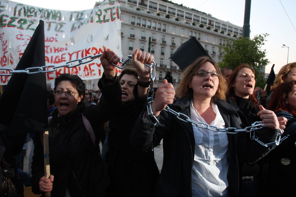 Unemployed school teachers chant slogans at an anti-government demonstration staged by civil servants outside the Greek Parliament in Athens on Tuesday. Greece’s debt crisis intensified Tuesday as its credit rating was cut to junk status. Associated Press photos (Associated Press photos)