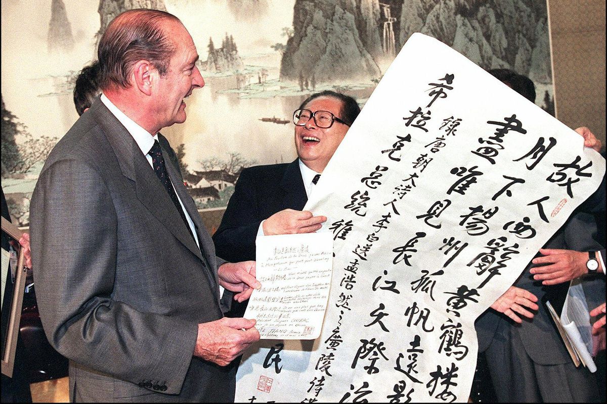 French President Jacques Chirac (L) reacts as he recieves from Chinese President Jiang Zemin (2L) a gift of a Tang dynasty poem written out personally by Jiang, 16 May at the Zhongnanhai leadership compound in Beijing where the leaders met to sign a joint declaration. The Sino-French presidential document for a global partnership called for a new political and economic world order and also recognized the universality of human rights.    (GERARD FOUET/Getty Images North America/TNS)