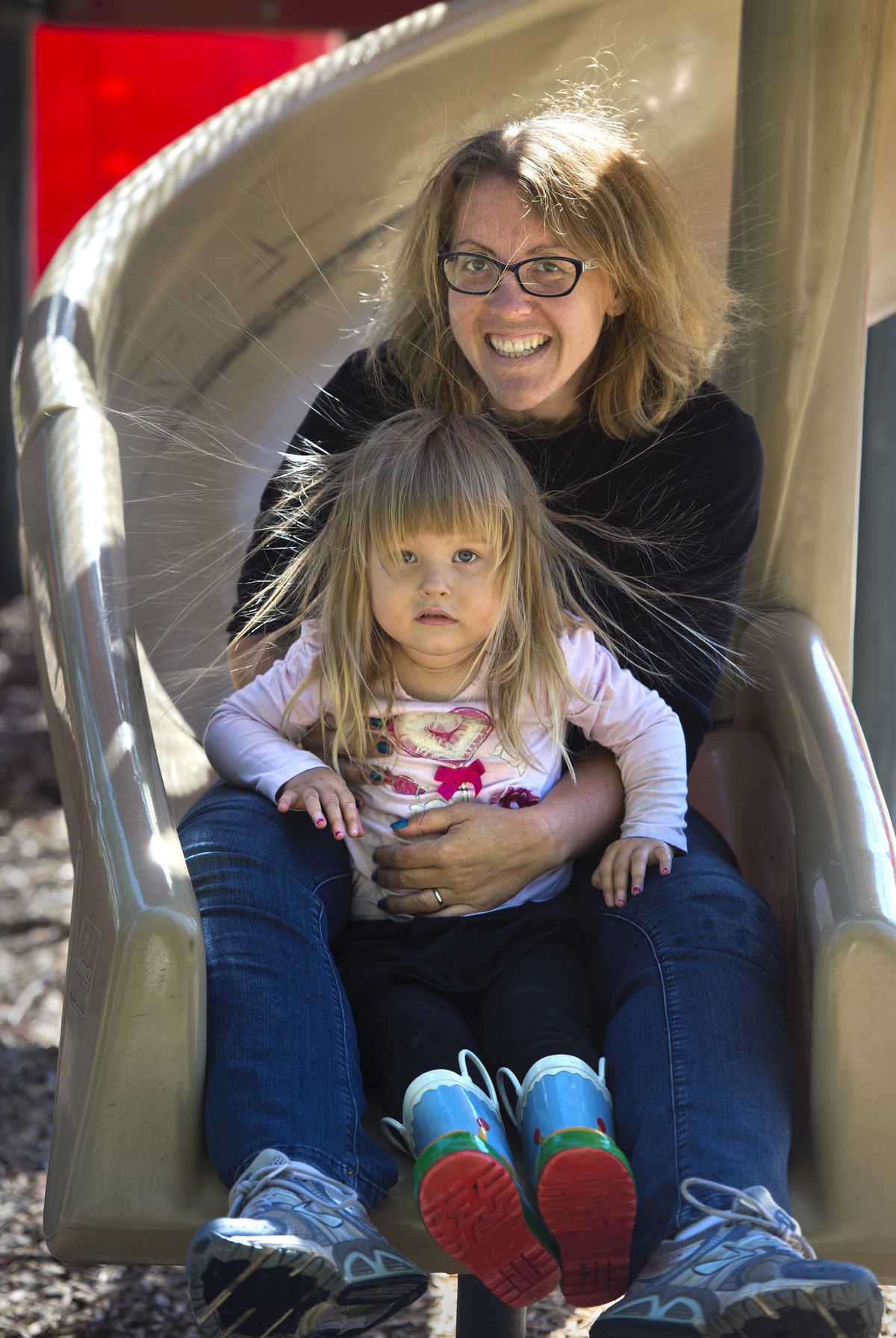 Now: Megan Steeber and her daughter Elsie have an electrifying time on the slide at Whittier Playground in west Spokane. (Dan Pelle)