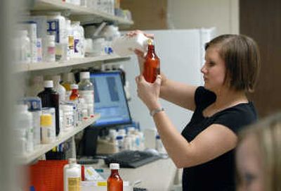 
Lindsey Pinckney, an intern at Sacred Heart Pharmacy, fills a prescription for the pain medication Hydrocodone on Friday.   
 (Dan Pelle / The Spokesman-Review)