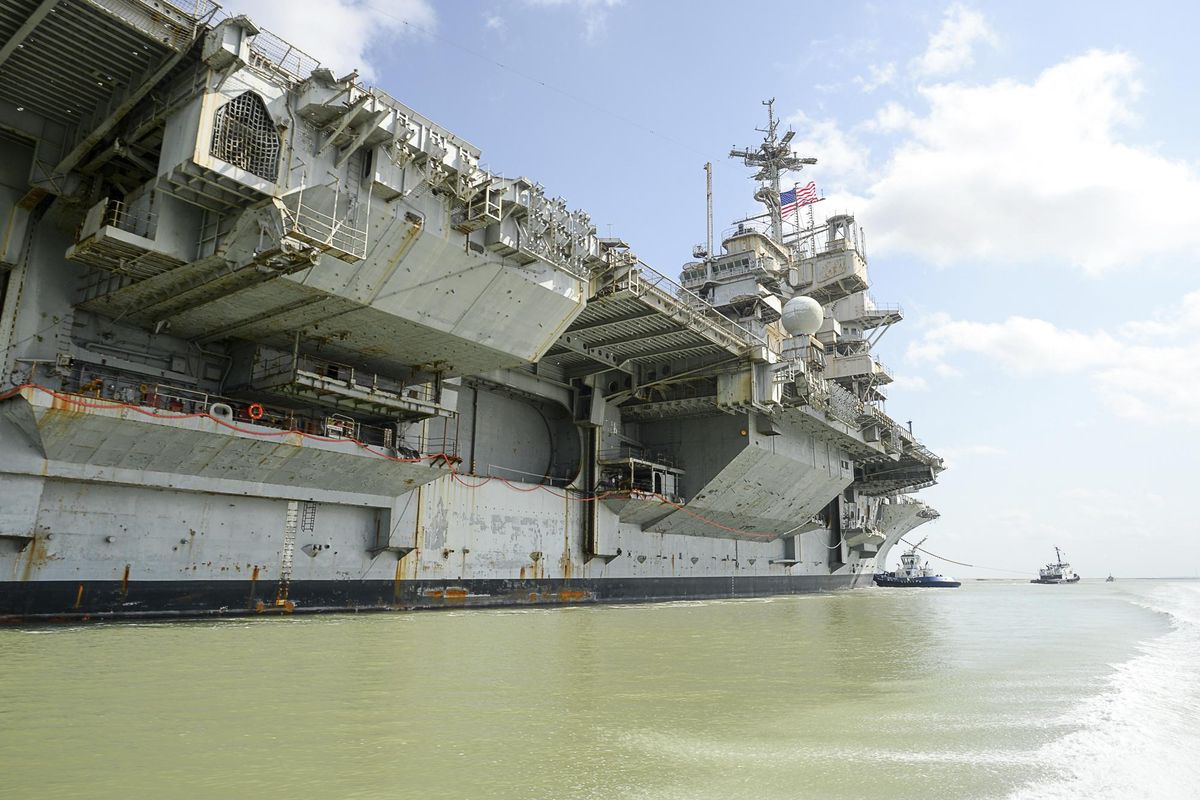 In this June 1, 2017, file photo, the decommissioned USS Independence is towed on her final voyage to the Port of Brownsville near Port Isabel, Texas. The Suquamish Tribe and two environmental groups have sued the U.S. Navy, alleging the Navy cleaned the mothballed 60,000-ton USS Independence aircraft carrier in Puget Sound in violation of federal clean-water laws. The ship was cleaned in waters near Bremerton, Wash., in January and February before it was towed to Brownsville, Texas, earlier this month to be dismantled. The tribe, Washington Environmental Council and Puget Soundkeeper Alliance say the Navy scraped the ship’s hull and sent toxic copper-based paint, zinc and other pollutants into the water. (Jason Hoekema / AP)