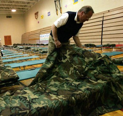 
Oregon Gov. Ted Kulongoski checks bedding at a center being set up for Hurricane Katrina evacuees at a closed high school in Portland on Monday. 
 (Associated Press / The Spokesman-Review)