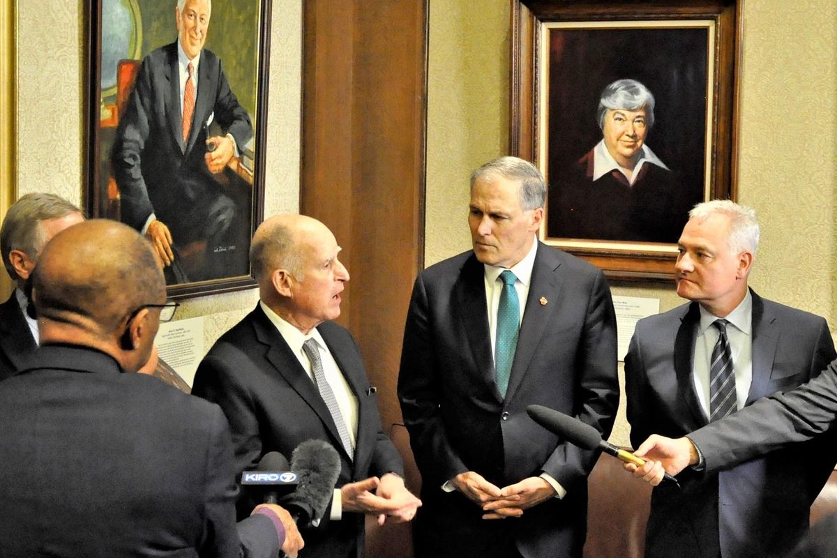 OLYMPIA – Former California Gov. Jerry Brown, left, Washington Gov. Jay Inslee and Senate Energy Committee Chairman Reuven Carlyle, D-Seattle, meet with reporters in the lobby of the Inslee’s Capitol office, after talking with legislators about the importance of passing new laws to fight climate change. (Jim Camden / The Spokesman-Review)