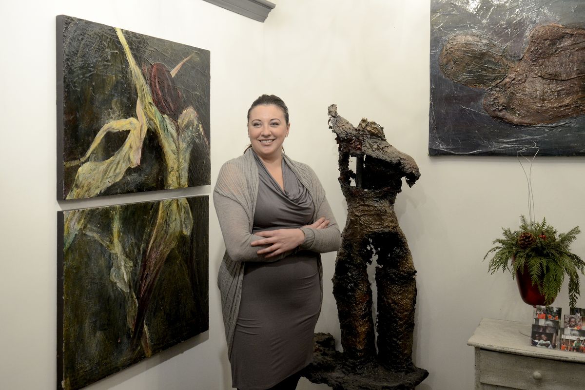 Jennifer Gray stands with her art work at Josefine’s, her hair salon in downtown Spokane Tuesday. The painting at left is acrylic on wooden panels, and the figure is papier-mâché over chicken wire. (JESSE TINSLEY PHOTOS)