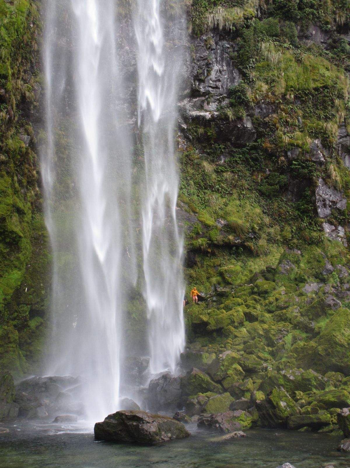 Above: A hiker walks behind Sutherland Falls, New Zealand’s largest waterfall, in Milford Sound. The falls are a side-trip option for hikers on the Milford Track.