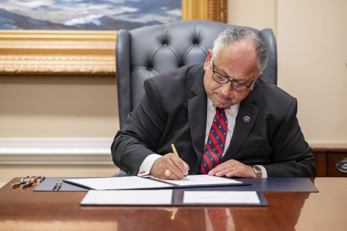 Secretary of the Navy Carlos Del Toro signs an announcement of the full exoneration of the remaining 256 defendants of the 1944 Port Chicago general and summary courts-martial at the Pentagon in Arlington, Va., on Wednesday.   (Craig Hudson/For the Washington Post)
