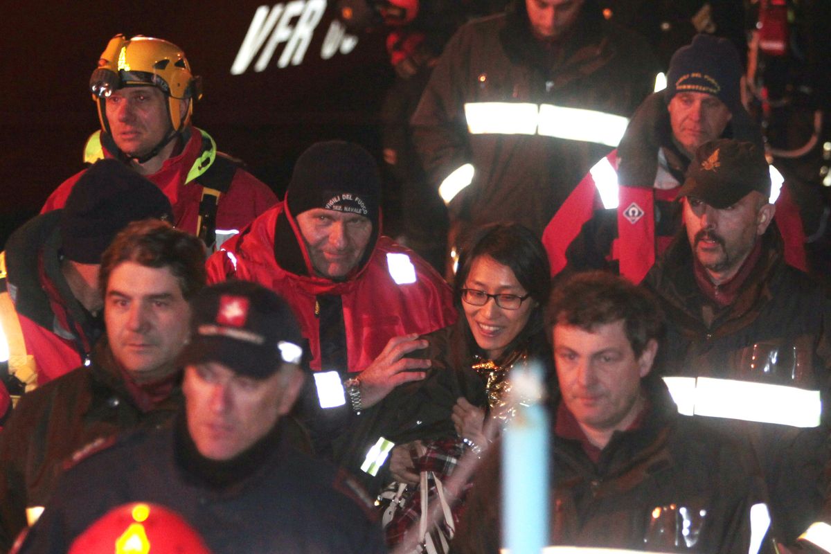 A passenger from South Korea, center, walks with Italian Firefighters after being rescued from the luxury cruise ship Costa Concordia which ran aground the tiny Tuscan island of Giglio, Italy, Sunday, Jan. 15, 2012. The luxury cruise ship ran aground off the coast of Tuscany, sending water pouring in through a 160-foot (50-meter) gash in the hull and forcing the evacuation of some 4,200 people from the listing vessel early Saturday, the Italian coast guard said. (Gregorio Borgia / Associated Press)
