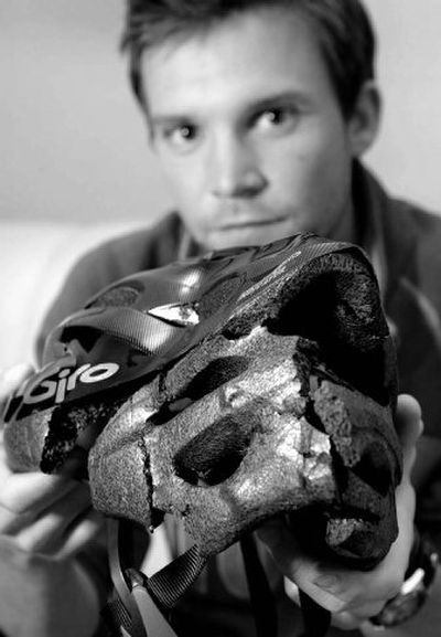 
 Ryan Lipscomb holds the bicycle helmet he was wearing  when a delivery truck reportedly ran over his head. 
 (Associated Press / The Spokesman-Review)
