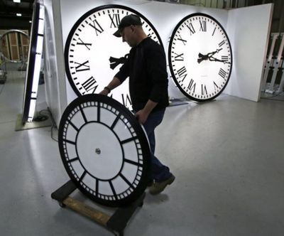 Dan LaMoore wheels a clock away from the test area as it is prepared to be shipped to a Tennessee school at the Electric Time Company in Medfield, Mass., Thursday. Most Americans lost an hour of sleep over the weekend, but gained an hour of evening light for months ahead, as Daylight Saving Time returned. (AP Photo/Charles Krupa)