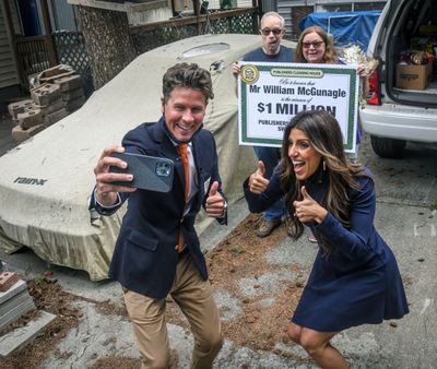 Howie Guja, left, and Danielle Lam, of the Publishers Clearing House Prize Patrol, take a picture Friday after awarding a $1 million prize to William McGunagle and his wife, Kat, both of Spokane.  (DAN PELLE/THE SPOKESMAN-REVIEW)
